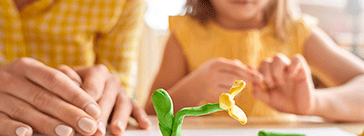 Barn-och vuxenhänder med en blomma