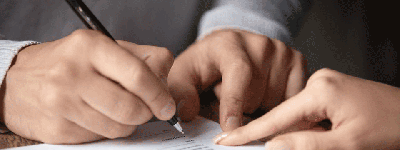 Händer som håller i en penna och skriver under ett kontrakt